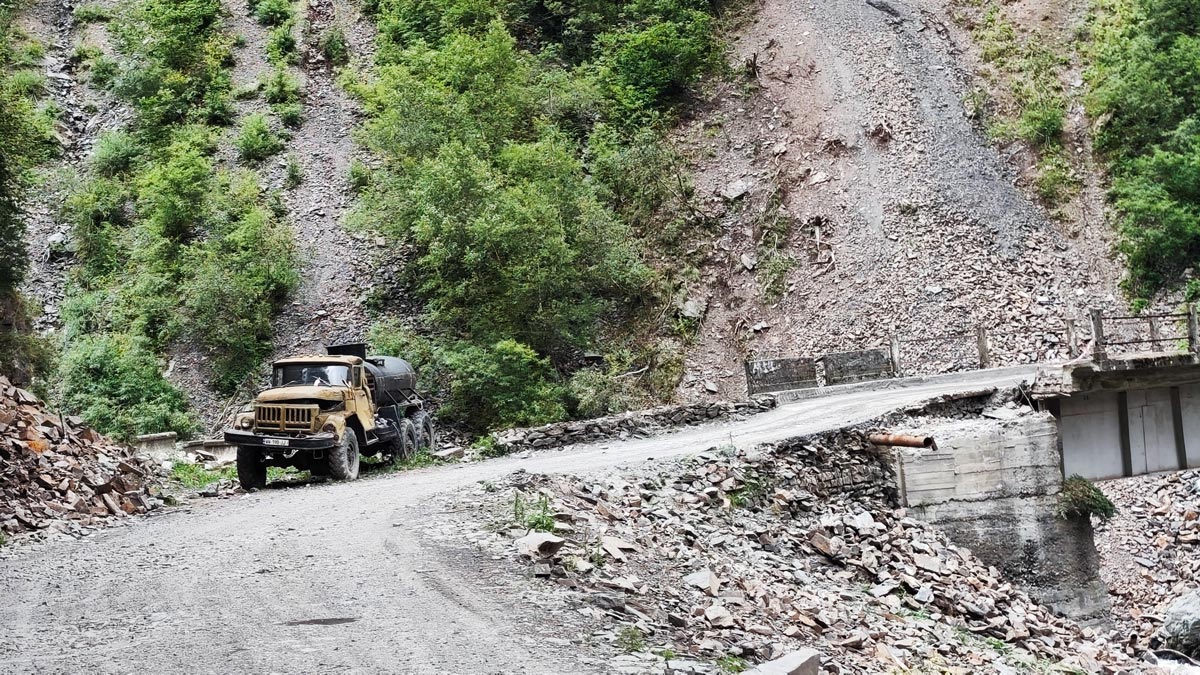 Ein alter sowjetischer ZIL-LKW geparkt nahe einer engen Brücke auf der rauen Bergstraße des Abano-Passes in Tuschetien, Georgien